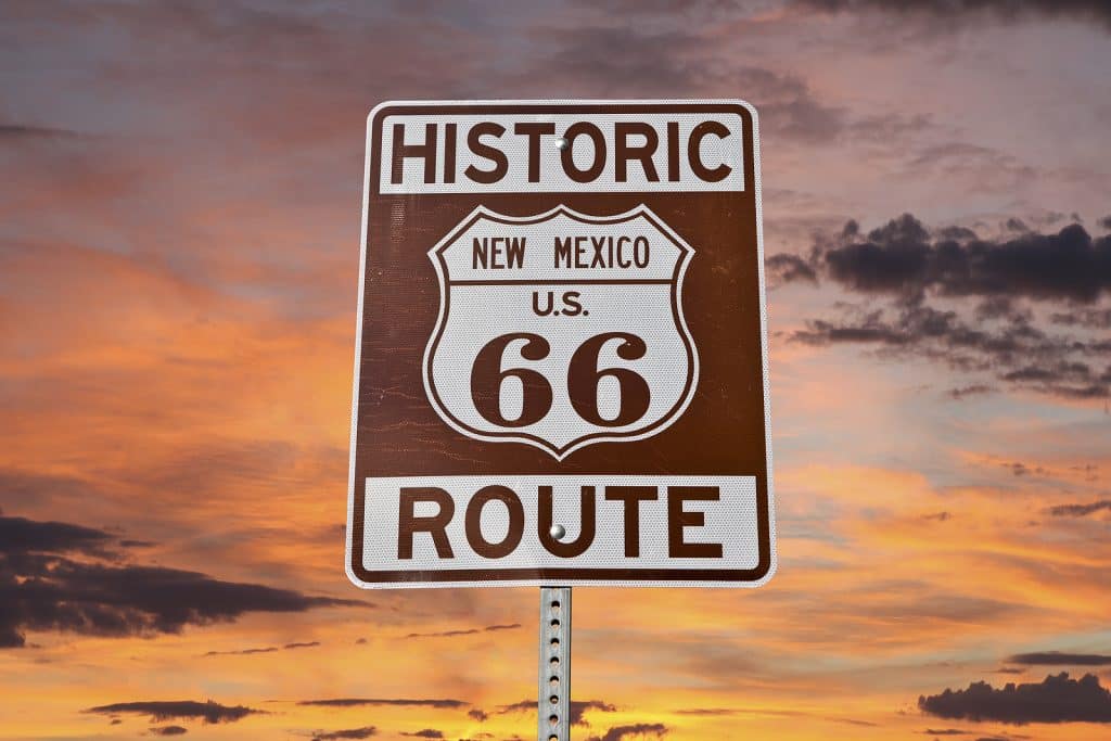 Historic Route 66 New Mexico sign with sunset sky.